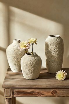 three vases sitting on top of a wooden table