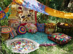 an outdoor area with many different items on the ground and in the grass, there is a tent that has been set up to be used as a bed