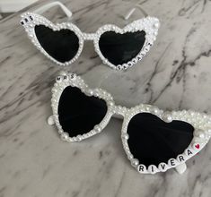 These custom made personalized sunglasses are perfect for a Bachelorette Weekend, Bridal Shower, or Wedding Weekend. They are made to order with your NEW last name or saying that you like! These are the perfect gift for you BFF or treat your self ;) Can be customized with any name/ saying!  Each pearl is hand placed. These sunglasses will be shipped in bubble for protection and should be handled with care. These sunglasses do take a bit more time but should ship within a week of ordering! If you need them sooner- please let us know and we will give you current availability  Heart sunglasses measure approx. 15 x 6.8 x 6.3 cm/ 5.91 x 2.68 x 2.48 inches, with the bridge of approx. 1.3 cm/ 0.51 inches in length and the legs of the sunglasses measuring about 14 cm/ 5.51 inches, which are suitab Customizable White Adjustable Sunglasses, Bridesmaid Sunglasses, Bridal Sunglasses, Bling Sunglasses, Personalized Sunglasses, Bach Party, Heart Sunglasses, Bachelorette Weekend, Wedding Weekend