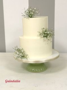 a three tiered white cake with flowers on top