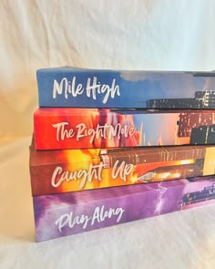 four books stacked on top of each other in front of a white sheeted background