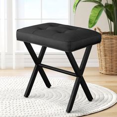 a black stool sitting on top of a white rug