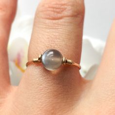 "This beautifully simple ring is lovingly handmade with a Moonstone and a choice of 14k Gold Filled, 14k Rose Gold Filled or Sterling Silver band. M A T E R I A L S: * Grey Moonstone * 14k Gold Filled, 14k Rose Gold Filled or Sterling Silver S I Z E: *  Gemstone - Approximately 6mm *  Band Thickness - Approximately 0.8-1mm  All of our jewellery is carefully handmade using good quality materials and handpicked gemstones, with the aim to produce quality pieces that you can love & wear for years to come.  M O O N S T O N E: * June Birthstone * Talisman for Cancer, Libra & Scorpio * Third Eye Chakra, Solar Plexus Chakra A stone for \"new beginnings\", Moonstone is a stone of inner growth and strength.  It soothes emotional instability and stress, and stabilises the emotions, providing calmness 14k Gold Filled Gemstone Rings For Gift, Adjustable 14k Yellow Gold Moonstone Ring, Delicate Adjustable Moonstone Ring, 14k Gold Filled Round Band Jewelry Gift, Adjustable 14k Gold Moonstone Ring, Dainty Stackable Moonstone Jewelry, Adjustable Round Moonstone Ring In Minimalist Style, Adjustable Fine Jewelry Moonstone Ring, Stackable Moonstone Jewelry Gift