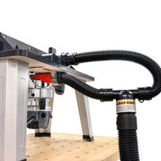 a machine that is sitting on top of a wooden shelf with hoses attached to it