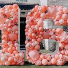 the letter b made out of balloons is in front of a building with flowers on it