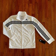 Adidas Full-Zip White Boys Tricot Jacket With Stripes That Run Down Sleeve. Welt Pockets, Rib Sleeve Cuff And Rib Hem. Embroidered Adidas Brand Mark On Wearer's Left Chest. Condition: Brand New With Tags. Size: Boys Medium (10/12) Material: 100% Polyester, Zipper Closure. Machine Wash White Track Jacket With Zipper For Spring, White Track Jacket For Spring, White Spring Track Jacket With Zipper, White Zipper Track Jacket For Winter, White Casual Track Jacket With Three Stripes, Casual White Track Jacket With Three Stripes, White Casual Track Jacket For Winter, Cotton Outerwear With Three Stripes For Fall, White Track Jacket With Zipper Closure For Fall