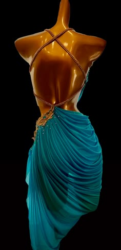 a mannequin wearing a blue dress with gold chains on it's back