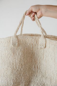 Join the early access shopping list here This gorgeous handwoven sisal tote bag is the perfect carryall. Bring it to the beach, on an overnight trip, or use it as extra storage in your home or car. Made from local sisal grass in Kenya, the preparation process is extensive even before dyeing and weaving begins, as the grass is first harvested and rolled by hand. 22" x 10" x 12" Natural Fiber Woven Straw Travel Bag, Natural Fiber Straw Bag With Weaving For Travel, Woven Natural Fiber Straw Bag For Travel, Natural Weaved Straw Bag For Travel, Handwoven Natural Straw Bag, Natural Handwoven Tote Beach Bag, Fair Trade Natural Color Tote Beach Bag, Natural Handwoven Palm Leaf Crochet Bag, Large Natural Color Handwoven Bag