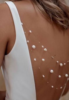 the back of a woman's dress with pearls on it