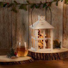 a glass of wine sitting on top of a wooden table next to a lit candle