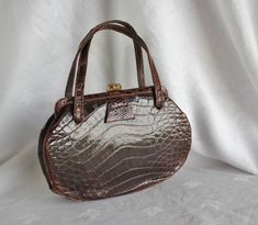 "Vintage Brown Alligator Leather Handbag Purse The very charming purse features 2 leather strap handles, secure clasp closure. The lining is a lovely soft brown with a slip pocket, and a zippered pocket. The purse measures 9\" across at the widest x 6\" high x 2 3/8\" deep at bottom. It is in very nice condition with some wear on the outside handles. The leather is clean and soft on the outside and inside. No odor, smoke free home." Handheld Textured Leather Brown Satchel, Brown Crocodile Pattern Satchel For Daily Use, Daily Use Brown Satchel With Crocodile Pattern, Classic Brown Crocodile Pattern Shoulder Bag, Classic Brown Bag With Crocodile Pattern, Brown Crocodile Pattern Evening Shoulder Bag, Evening Brown Crocodile Pattern Shoulder Bag, Evening Brown Bag With Crocodile Pattern, Brown Crocodile Pattern Evening Bag