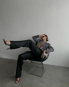 a woman laying on top of a metal chair