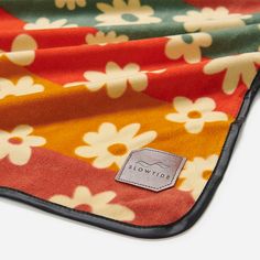 an orange and yellow flowered blanket with a label on the bottom that says slowie