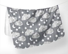 a black and white photo of clouds and stars on a clothes line with the moon in the sky