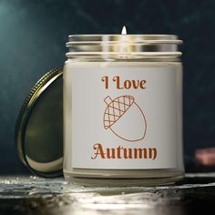 a candle with the words i love autumn written on it