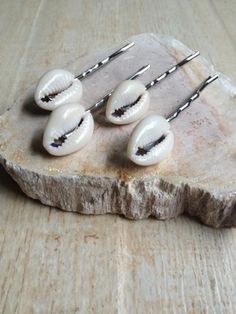 These cowrie shell hair pins would be great as a set or on their own! They would be a perfect addition for a beach wedding, summer vacation, music festival, mermaid costume or for everyday fun. The shells and are securely attached to a silver metal hair pin that is two inches in length. The cowrie shells are 3/4 inch in height and 1/2 inch in width. This shell hair pin is also available in gold and bronze finish, see the last photo. SAVE Order 10 and get one FREE SEVENTEEN cowrie shell hair pins Girl Mermaid Costume, Cowrie Shell Hair, Music Festival Birthday, Festival Mermaid, Girls Mermaid Costume, Hippie Music, Pool Party Favors, Seashell Projects, Mermaid Crafts