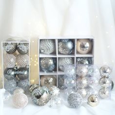 there are many silver and white ornaments in the box