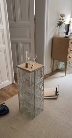 a glass cabinet sitting in the middle of a living room next to a door and carpet