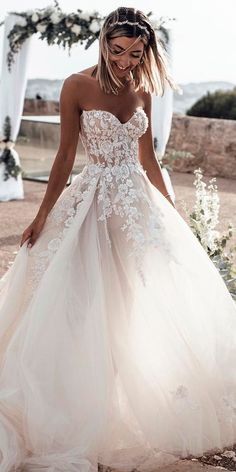 a woman in a wedding dress is standing outside