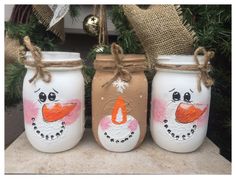 three painted mason jars with snowmen on them