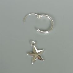 a pair of silver earrings with a star hanging from it