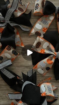 several black and orange hair bows on a wooden surface with the words halloween written in white