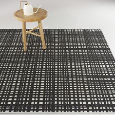 a black and white area rug with a tea pot on the table next to it