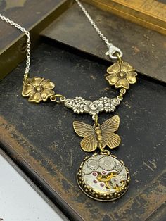 Delicate floral elements add femininity and elegance to this simple butterfly drop watch pendant. A great addition to your Victorian Magpie collection!  Neo Victorian steampunk necklace pendant Steampunk Butterfly, Industrial Necklace, Costume Jewelry Crafts, Victorian Accessories, Steampunk Pendant, Watch Pendant, Simple Butterfly, Steam Punk Jewelry, Neo Victorian