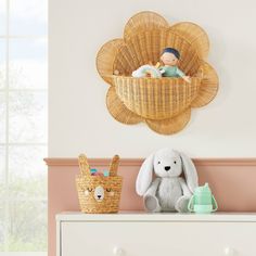 a white dresser topped with a stuffed animal next to a basket