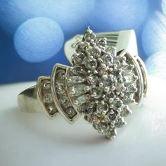 Details: Size: 9.75 Weight: 5 grams Stone:  Diamond, Round,  42  x .018ct. ea.; Baguette, 6 x .04ct.ea.; L/I1 Setting: Prong/Channel Markings: 10K (Tested, Verified, & Guaranteed) Condition:  Gently used pre-owned condition.  Minor signs of wear & tear visible but no major or excessive damage; Please see detailed images to determine the condition. Will be cleaned & polished prior to shipping. Ring shank is slightly misshaped. Dazzling Cluster Baguette Diamond Rings, Dazzling Baguette Diamond Cluster Rings, Dazzling Cluster Rings With Baguette Diamonds, Formal Cluster Diamond Ring With Baguette Diamonds, Classic Cluster Diamond Ring With Baguette Diamonds, Silver Cluster Diamond Ring With Baguette Diamonds, Diamond White Cluster Ring With Baguette Diamonds, Diamond White Cluster Jewelry With Baguette Diamonds, Silver Cluster Ring With Baguette Diamonds