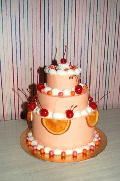 a three tiered cake with orange slices and cherries