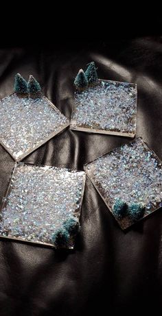 four pieces of glass sitting on top of a black leather couch