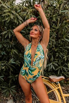 We guarantee you'll want to pack this gorgeous yellow one piece swimsuit for your tropical destination with its lightweight four-way stretchy material, subtle ribbed texturing, light blue and green hued palm leaf print, ultra deep v-cut neckline, wide shoulder straps with a low cut back, and a flattering form fitting silhouette that ends in cheeky fit bottoms! This swimsuit comes with built in padding (not removable).                                   Measurements S variant has  a Bust of 34", Yellow One Piece, Tropical Destinations, Impressions Online Boutique, Model Fits, V Cut, Palm Leaf, V Cuts, Women Clothing Boutique, Leaf Print