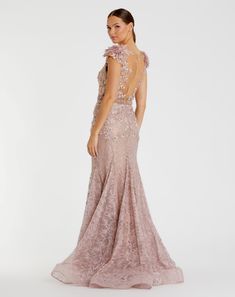 a woman in a long pink dress with an open back and floral appliques