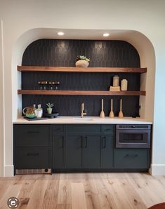 a kitchen with black cabinets and white counter tops, wood flooring and built in shelving