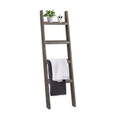 a wooden ladder shelf with towel and potted plant