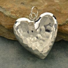 Sterling Silver Puffed Heart Charm - Hammered Heart, Valentines, Puffy Pendants, Big Heart, Heart Pendant, Silver Puffed Heart, Mother's Day Gifts Sterling Silver Hammer Finish Puffed Heart. An adorable charm! Whether swinging from a delicate chain necklace or dangling on a beaded bracelet, this little charm is sure to please. THIS LISTING IS FOR ONE (1) CHARM. PHOTO FOR DISPLAY ONLY. Large Heart - H: 8.0 L: 25.0 W: 25.0mm Includes a 7 mm soldered jump ring not included in measurements. Small He Jewelry Wallpaper, Hammered Silver Jewelry, Silver Jewelry Diy, German Silver Jewelry, Jewelry Bracelets Silver, Puffed Heart, Puffy Heart, Silver Jewelry Rings, Silver Jewelry Handmade