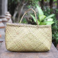 Add a natural look to your ensemble with this woven tote bag from Balinese artisan team Dewa Brother. Crafted from woven water hyacinth reeds the open-top bag features a woven pattern in a natural color two straps that fit comfortably over your shoulder and an open pocket. Eco-friendly Palm Leaf Bag With Open Weave, Eco-friendly Rectangular Open Weave Straw Bag, Traditional Shoulder Bag With Bamboo Handle, Eco-friendly Shoulder Bag With Bamboo Handle, Eco-friendly Beach Bag With Bamboo Handle For Daily Use, Eco-friendly Handwoven Rectangular Straw Bag, Fair Trade Natural Color Tote Beach Bag, Traditional Summer Shoulder Bag With Bamboo Handle, Eco-friendly Straw Tote Bag With Bamboo Handle