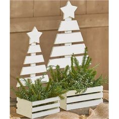 two white wooden christmas trees sitting on top of a table