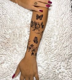 a woman's arm with flowers and butterflies on it