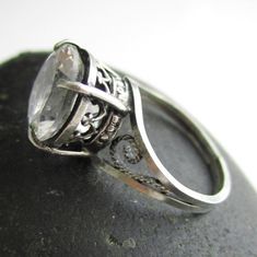 "A big white topaz (blingy - although hard to see it in the pictures) has been set in sterling silver, complemented with filigree swirls. The design is simple enough to be classy and the stone is large enough to draw some attention to one's hand. The stone is a little under 1/2\" in diameter and the ring is a size 6.5, but this can be adjusted a bit." Classic White Topaz Ring With Diamond Accents, Vintage Sterling Silver Topaz Ring With Filigree, Vintage Sterling Silver Topaz Filigree Ring, Victorian Silver Topaz Ring With Filigree, Silver Victorian Topaz Ring With Filigree, Vintage Sterling Silver Topaz Ring With Intricate Design, Silver Jewelry With Rose Cut Diamonds And White Topaz, Antique Sterling Silver Topaz Wedding Ring, Victorian White Jewelry With Center Stone