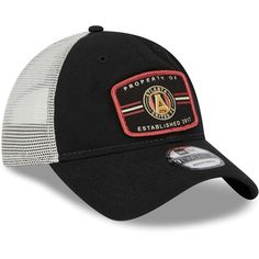 the black and white trucker hat has an embroidered patch on the front, which reads property