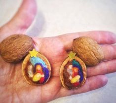 there are two nut shells in the palm of someone's hand, one with a nativity scene on it