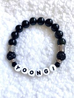 "Represent for Suga- or as we like to call him: Yoongi! BTS Yoongi Genuine Obsidian gemstone beaded bracelet in black to represent his mic color, with black and silver pavé accents. Letters are printed porcelain- NO PLASTIC. *Size can vary from 1/8\" to 1/4\" depending on bead type/size." Trendy Adjustable Black Crystal Bracelet, Casual Black Stretch Bracelet With Gemstone Beads, Casual Black Bracelets For Streetwear, Personalized Black Bracelets With Round Beads, Personalized Black Bracelet With Round Beads, Black Personalized Name Bracelet With Round Beads, Trendy Black Beaded Bracelet With 8mm Beads, Black Name Bracelet With Round Beads, Personalized Black Name Bracelet With Round Beads