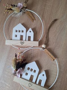 two small wooden houses on top of a table next to some string and wood decorations