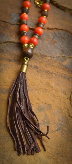 Orange jade, Tibetan agate, coconut shell, wood and gold chain with re-purposed, dark brown, signature, bullet shell leather tassel. Bohemian style necklace is approximately 33" in length. Every item sold plants a tree through our partnership with One Tree Planted. Wood And Gold, Bullet Shell, Pave Necklace, Horn Necklace, Horn Pendant, African Turquoise, Pave Pendant, Natural Coral, Trendy Necklaces