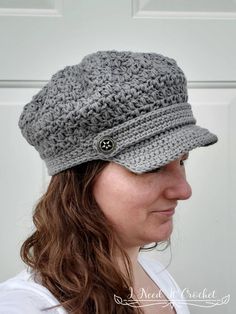 a woman wearing a gray crochet hat with buttons on the brimmed