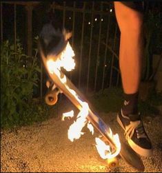 a person on a skateboard with flames coming out of the bottom part of it