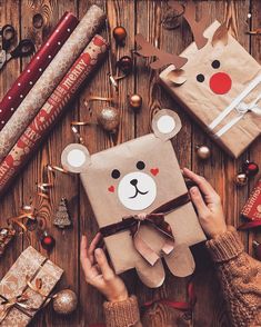 someone is holding a brown gift bag with a bear on it and other christmas decorations