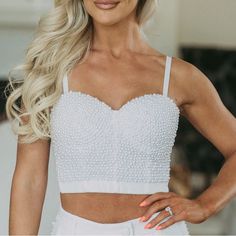 This White Bustier Crop Top Lends A Classic Look With Modern Flair. Featuring Adjustable Spaghetti Straps And A Clasp Closure Back, The Pearl Accents Add The Perfect Touch Of Elegance. Ideal For A Night Out Or Special Occasion! 93% Polyester, 7% Spandex Model Is 5'5" With A 35" Bust And 26" Waist And Wearing A Small. Summer Tops With Spaghetti Straps And Boned Bodice, Summer Camisole With Boned Bodice, Elegant Bodice With Built-in Bra For Summer, Elegant Tank Top With Sweetheart Neckline For Party, Elegant Crop Top With Boned Bodice And Spaghetti Straps, Spring Sleeveless Camisole With Boned Bodice, Party Tank Top With Spaghetti Straps And Boned Bodice, Party Camisole With Built-in Bra And Sweetheart Neckline, Party Tank Top With Boned Bodice And Spaghetti Straps